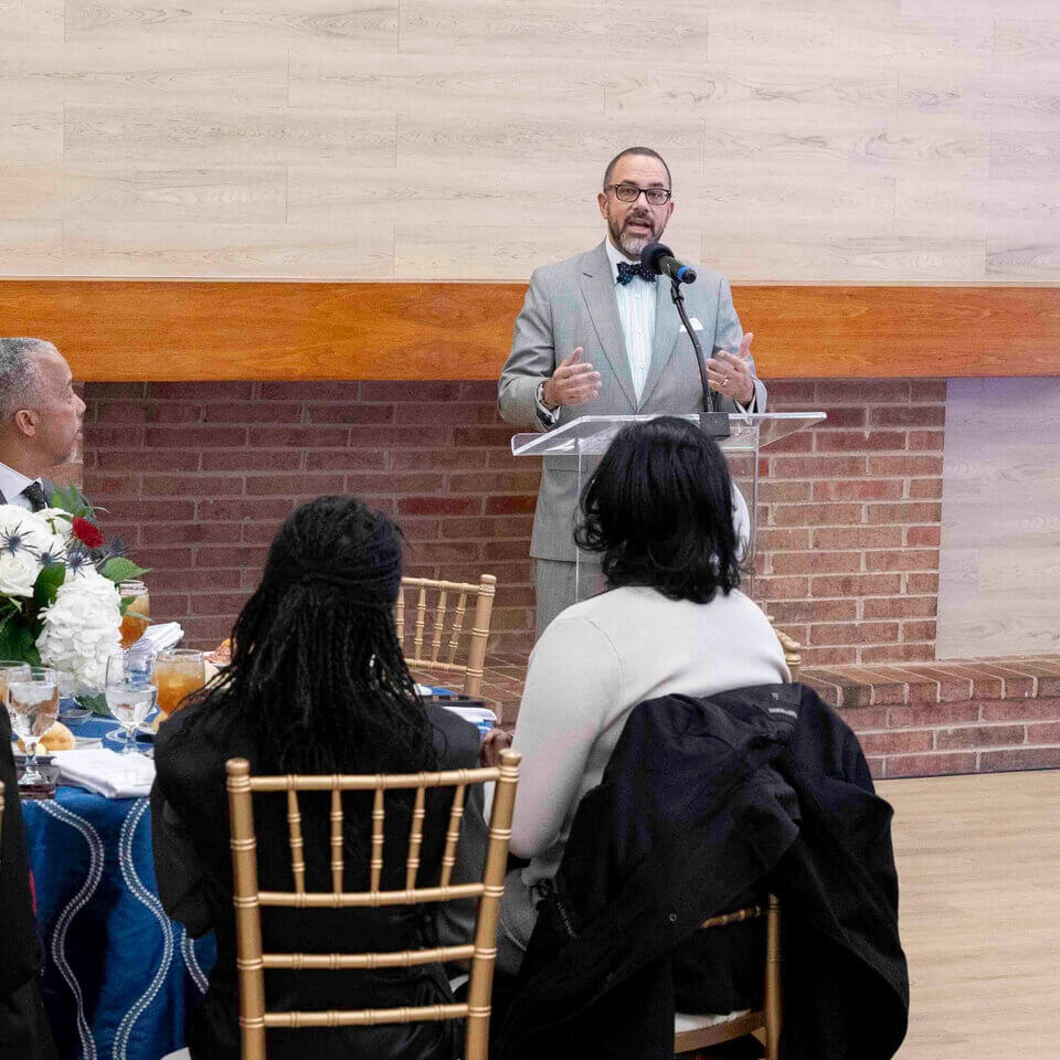 Faculty, staff and guests listen to a speaker at an OCR reception.