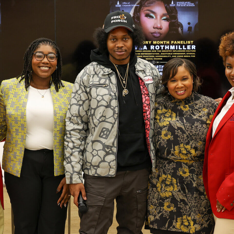 Howard students and special guests smiling in front of a banner for event with the Warner Music and Blavatnik Center for Music Business Education titled, “Power & Platforms: The Influence of Entertainment of Social Change"